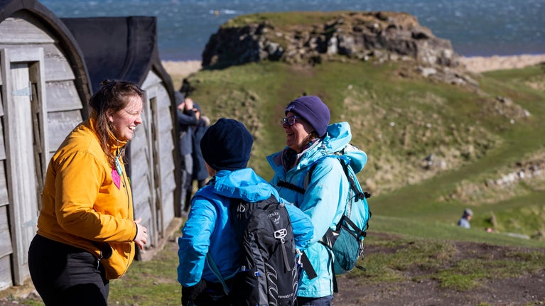 Staff member speaking with visitors at Lindisfarne Castle, Holy Island, Northumberland